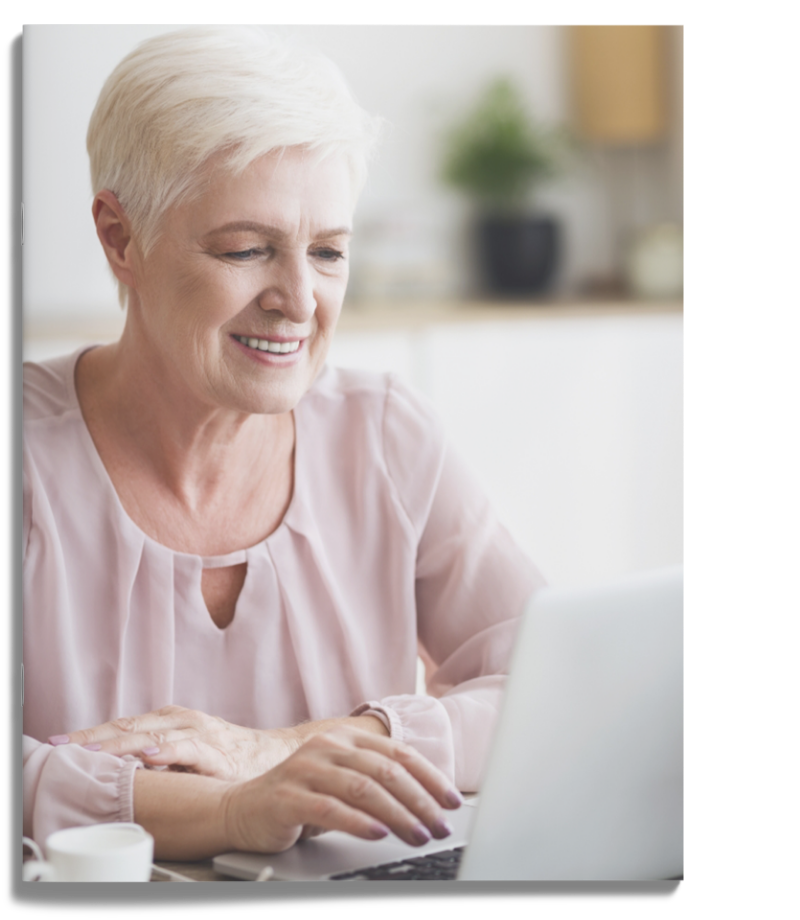 A smiling woman working on a laptop.